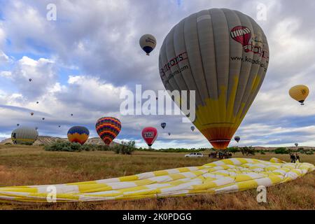 GOREME/TÜRKEI - 26. Juni 2022: Heißluftballons landen am Ende der Tour in der Nähe von goreme. Stockfoto