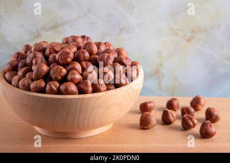 Schale voller Haselnüsse auf Holzhintergrund Stockfoto