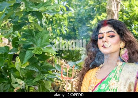 Verheiratete Frauen, die Dhunuchi-Tanz anlässlich der Durga Agomoni als Ritual aufführen, bedeckten den gesamten Bereich mit dem Heiligen Rauch. Stockfoto