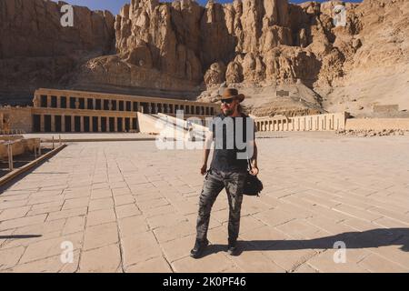 Weißer Mann Tourist, der einen antiken Totentempel der Hatschepsut in der Nähe von Luxor, Ägypten, besucht Stockfoto