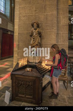 Frankreich. Auvergne. Haute-Loire (43) Le Puy-en-Velay. Am Anfang der Route Santiago de Compostela zündet ein junger Pilger vor dem eine Kerze an Stockfoto