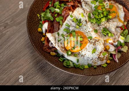 Nahaufnahme leckere, leckere und fettige Spiegeleier mit Fleisch und Speck. Food Delivery und Fast Food Service für beschäftigte Menschen Stockfoto