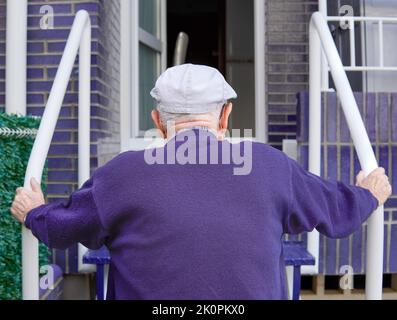 Alter Mann von hinten, der eine Leiter klettert Stockfoto