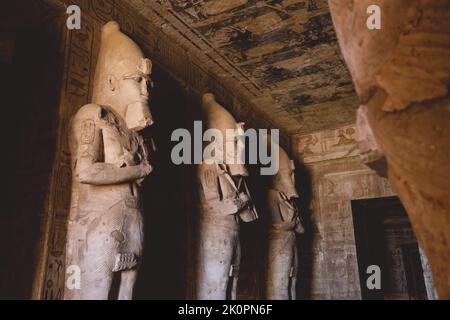 Innenansicht mit einer alten ägyptischen Statuen von Ramesses verbunden mit dem gott Osiris im Großen Tempel in Abu Simbel, Ägypten Stockfoto