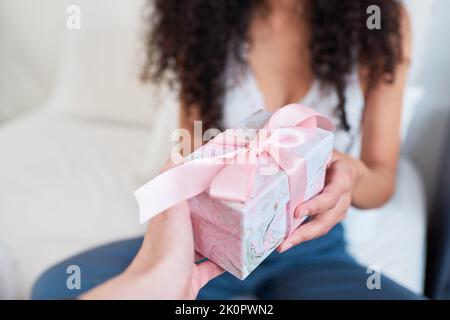 Nahaufnahme der Hand geben hübsches Geschenk in rosa Schleife im Bett gewickelt Stockfoto