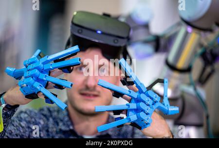 13. September 2022, Sachsen, Leipzig: Dominik Grzelak von der Technischen Universität Dresden präsentiert seine Arbeiten zum sogenannten Sniffbot-Projekt auf dem Robotics Festival in Leipzig. Mit VR-Brille und geeigneten Handschuhen steuert ein Bediener einen Roboter, um Gaslecks zu erkennen. Nach Angaben des Veranstalters bringt das Festival mehr als 400 internationale Entscheidungsträger, Anwender, Wissenschaftler, Investoren und die Top 30 Startups der Robotik zusammen. Ansätze und Anwendungen, die die Arbeitswelt in der Industrie sowie in kleinen und mittleren Unternehmen und im Handwerk prägen, autom Stockfoto