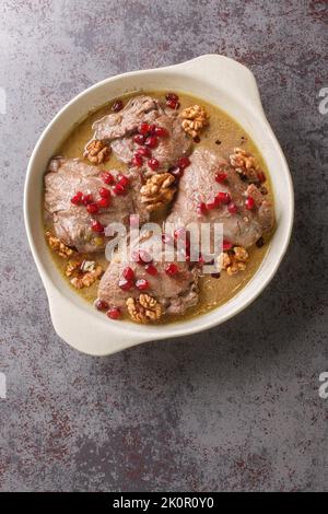 Fesenjan ist ein iranischer Granatapfel- und Hühnereintopf, der aus gemahlenen Walnüssen, Zwiebeln, Kürbis, Zimt und Granatapfelmelasse in einer Pfanne aus der Nähe hergestellt wird Stockfoto