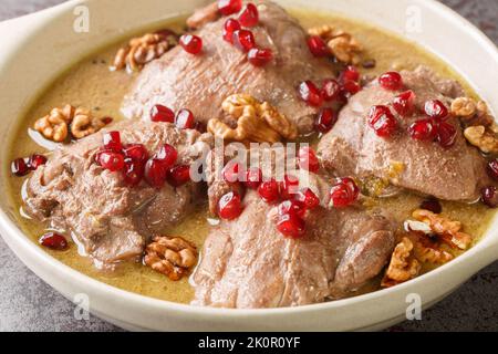 Khoreh Fesenjan zartes Huhn wird in einer Walnussgranatapfelsauce in einer Pfanne auf dem Tisch in der Nähe gekocht. Horizontal Stockfoto