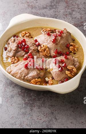 Fesenjan ist ein iranischer Granatapfel- und Hühnereintopf, der aus gemahlenen Walnüssen, Zwiebeln, Kürbis, Zimt und Granatapfelmelasse in einer Pfanne aus der Nähe hergestellt wird Stockfoto