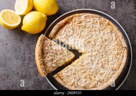 Geriebener Kuchen Zitronenkuchen aus der Nähe auf einem Teller auf dem Tisch. Horizontale Draufsicht von oben Stockfoto