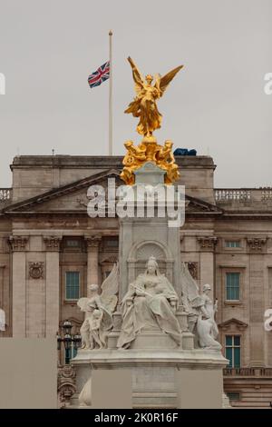 The Mall, London, Großbritannien. 13.. September 2022. Die Unionsflagge am Buckingham Palace, die nach dem Tod Ihrer Majestät Königin Elizabeth II. Auf den halben Mast gesenkt wurde, ist hinter dem Queen Victoria Memorial zu sehen. Der am längsten regierende britische Monarch starb am Tursday, dem 8.. September, im Alter von 96 Jahren in Balmoral, Schottland. Amanda Rose/Alamy Live News Stockfoto