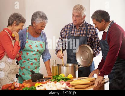 Kochen ist Liebe sichtbar gemacht. Eine Gruppe von Senioren Kochen in der Küche. Stockfoto