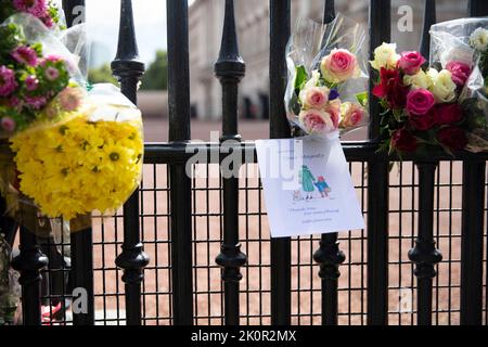 LONDON, Großbritannien - 2022. September: Blumen und Kondolenzbotschaften an den Toren des Buckingham Palace zu Ehren von Königin Elizabeth II Stockfoto