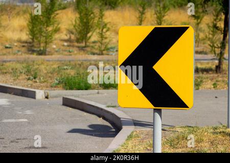 Biegen Sie in Richtung gelbes Schild ab Stockfoto