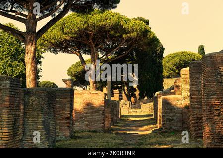 Sonnenuntergang Blick auf die Straße bei archäologischen römischen Ruinen in Ostia antica , ein schönes Reise-Archäologie-Ziel mit gut erhaltenen antiken römischen Ruinen ein Stockfoto