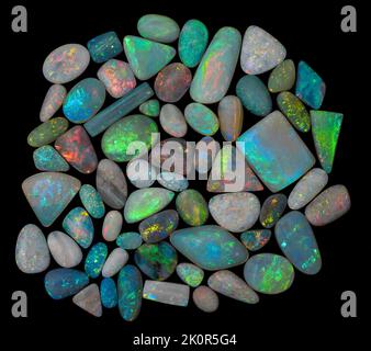 Australische Opal-Edelsteine, aufgenommen auf einem schwarzen Hintergrund, um die wunderschöne Farbe und das Muster dieses Natursteins hervorzuheben. Projekt mit Damien Hirst. Stockfoto