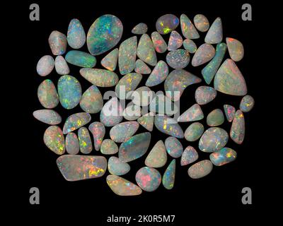 Australische Opal-Edelsteine, aufgenommen auf einem schwarzen Hintergrund, um die wunderschöne Farbe und das Muster dieses Natursteins hervorzuheben. Projekt mit Damien Hirst. Stockfoto