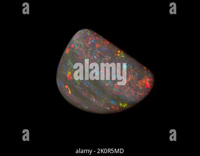 Australische Opal-Edelsteine, aufgenommen auf einem schwarzen Hintergrund, um die wunderschöne Farbe und das Muster dieses Natursteins hervorzuheben. Projekt mit Damien Hirst. Stockfoto