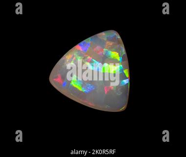 Australische Opal-Edelsteine, aufgenommen auf einem schwarzen Hintergrund, um die wunderschöne Farbe und das Muster dieses Natursteins hervorzuheben. Projekt mit Damien Hirst. Stockfoto