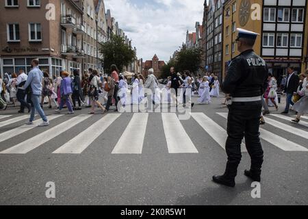 Danzig, Polen. 12.. Juli 2021. Ein Polizist schaut während der Prozession zu. Fronleichnam - liturgische Feier in der katholischen Kirche zu Ehren Jesu Christi im Allerheiligsten Sakrament. Eine Prozession von Gläubigen ging durch die Straßen von GDA?sk. (Foto von Agnieszka Pazdykiewicz/SOPA Images/Sipa USA) Quelle: SIPA USA/Alamy Live News Stockfoto