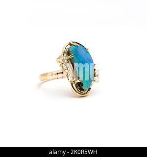 Australischer Queensland Boulder Opal in gelbgoldfarbenem Ring auf weißem Hintergrund dargestellt. Stockfoto