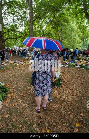 London, Großbritannien. 13. September 2022. Trotz des Regens bringen Mitglieder der Öffentlichkeit weiterhin Blumen und persönliche Kondolenzbotschaften in den Green Park in der Nähe des Buckingham Palastes, um ihre Trauer und Sympathie nach dem Tod von Königin Elizabeth II., der dienstältesten britischen Monarchin, auszudrücken, die am 8. September in Balmoral Castle starb. Es wird erwartet, dass Millionen von Besuchern nach London kommen, um den Sarg Ihrer Majestät Königin Elizabeth zu sehen, die vier Tage lang bis zur Beerdigung am Montag, dem 19. September, im Staat in der Westminster Hall liegen wird. Quelle: amer ghazzal/Alamy Live News Stockfoto