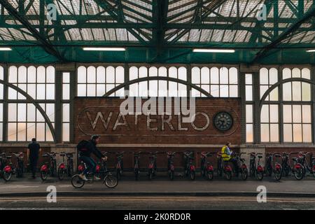 London, Großbritannien - 8. September 2022: Santander fährt mit der Dockingstation von Waterloo Station, der Mensch fährt vorbei. Santander Cycles sind Teil des Transports für Lond Stockfoto