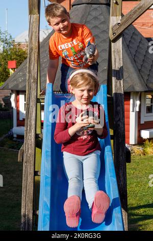 Geschwister auf der Folie Stockfoto