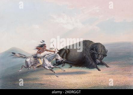 Jagd auf Buffalo. Ein Indianer auf dem Pferderücken schießt mit Pfeil und Bogen auf einen Büffel. American Bison (B. Bison). Aus Catlins nordamerikanischem indischem Portfolio, veröffentlicht in London 1844 vom Künstler, dem amerikanischen Abenteurer George Catlin, 1796 - 1872. Während vieler Reisen hat Catlin mit Stift und Pinsel die Bräuche und Lebensstile der indianischen Stämme aufgenommen. Stockfoto