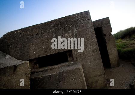 Eingestürzter Pillbox aus dem Zweiten Weltkrieg an der Küste. Stockfoto