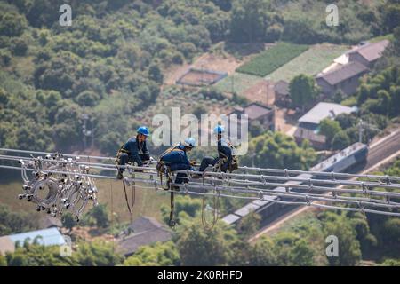 (220913) -- CHONGQING, 13. September 2022 (Xinhua) -- Techniker arbeiten während des Stromverdrahtungsbetriebs über den Yangtze-Fluss für das 800 kv-Ultrahochspannungs-Gleichstrom-Übertragungsleitungsprojekt (UHGÜ) in der Region Chongqing im Südwesten Chinas (Chongqing, 13. September 2022). Nach einer 13-tägigen Kampagne wurde am Dienstag der über den Jangtse-Fluss verdrahtungsbetrieb für das 800-kv-Ultrahochspannungs-Gleichstrom-Übertragungsleitungsprojekt (UHGÜ) in Baihetan-Zhejiang erfolgreich abgeschlossen. Die 2.140 Kilometer lange Strecke, deren Bau im Oktober 2021 begann, schlängelt sich durch Sichuan, Chongqing, Stockfoto