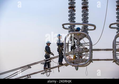 (220913) -- CHONGQING, 13. September 2022 (Xinhua) -- Techniker arbeiten während des Stromverdrahtungsbetriebs über den Yangtze-Fluss für das 800 kv-Ultrahochspannungs-Gleichstrom-Übertragungsleitungsprojekt (UHGÜ) in der Region Chongqing im Südwesten Chinas (Chongqing, 13. September 2022). Nach einer 13-tägigen Kampagne wurde am Dienstag der über den Jangtse-Fluss verdrahtungsbetrieb für das 800-kv-Ultrahochspannungs-Gleichstrom-Übertragungsleitungsprojekt (UHGÜ) in Baihetan-Zhejiang erfolgreich abgeschlossen. Die 2.140 Kilometer lange Strecke, deren Bau im Oktober 2021 begann, schlängelt sich durch Sichuan, Chongqing, Stockfoto