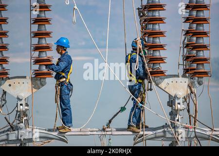 (220913) -- CHONGQING, 13. September 2022 (Xinhua) -- Techniker arbeiten während des Stromverdrahtungsbetriebs über den Yangtze-Fluss für das 800 kv-Ultrahochspannungs-Gleichstrom-Übertragungsleitungsprojekt (UHGÜ) in der Region Chongqing im Südwesten Chinas (Chongqing, 13. September 2022). Nach einer 13-tägigen Kampagne wurde am Dienstag der über den Jangtse-Fluss verdrahtungsbetrieb für das 800-kv-Ultrahochspannungs-Gleichstrom-Übertragungsleitungsprojekt (UHGÜ) in Baihetan-Zhejiang erfolgreich abgeschlossen. Die 2.140 Kilometer lange Strecke, deren Bau im Oktober 2021 begann, schlängelt sich durch Sichuan, Chongqing, Stockfoto