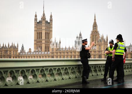 London, Großbritannien. 13. September 2022. Polizeibeamte unterhalten sich mit dem Parlament auf der Westminster Bridge vor dem Palast von Westminster. Die britische Königin Elizabeth II. Starb am 8. September 2022 im Alter von 96 Jahren. Am 14. September wird ihr Sarg in einer öffentlichen Prozession durch die Mall vom Buckingham Palace zum Parlament gebracht, wo er für mehrere Tage in der Westminster Hall verlegt wird. Quelle: Christian Charisius/dpa/Alamy Live News Stockfoto