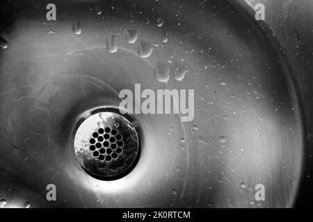 Alter Metallabfluss mit Wasserflecken und Flecken auf dem Stahlwaschbecken Stockfoto