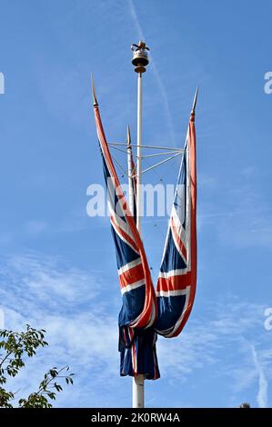 Arbeiter installierten Union Jacks in der Mall vor dem Staatsfuneral von Königin Elizabeth II. The Mall, London. VEREINIGTES KÖNIGREICH Stockfoto