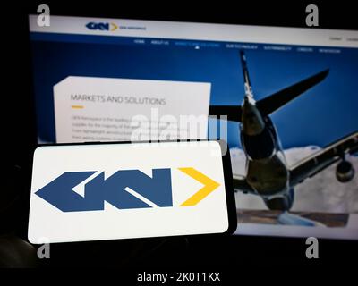 Person, die Mobiltelefon mit dem Logo der Luft- und Raumfahrt- und Automobilcomopany GKN Ltd. Auf dem Bildschirm vor der Business-Webseite hält. Konzentrieren Sie sich auf die Telefonanzeige. Stockfoto