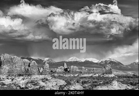 Turret Arch im Arches National Park, Moab, Utah mit Sturmwolken über den La Sal Bergen dahinter. Stockfoto