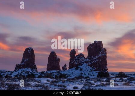 Enrada Sandsteinfelsen mit Schnee im Winter bei Sonnenuntergang in der Windows Sektion im Arches National Park, Moab, Utah. Stockfoto