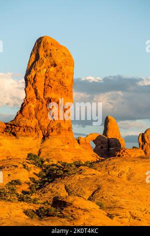 Eine Entrada-Sandsteinspitze mit Turret Arch im Arches National Park, Moab, Utah. Stockfoto