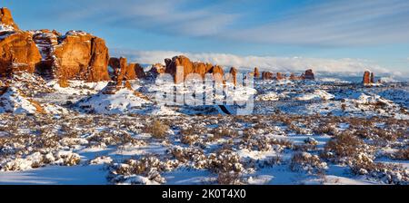 Elephant Butte mit Doppelbogen, Parade von Elefanten & Revolverbogen im Schnee im Winter. Arches National Park, Moab, Utah. Stockfoto