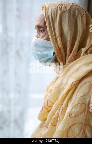 Porträt einer alten inderin, die eine chirurgische Maske trägt Stockfoto