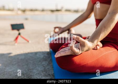 Erwachsene Frau, die Video-Tutorial des Yoga-Kurses auf dem Mobiltelefon aufzeichnet - Yoga Virtual Fitness class concept Stockfoto