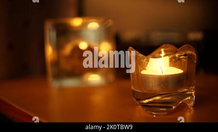 Kerzenlicht in Glas kleinen Glas. Dunkle Nacht Hintergrund Stockfoto