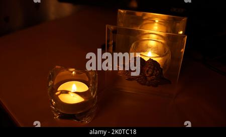 Kerzenlicht in Glas kleinen Glas. Dunkle Nacht Hintergrund Stockfoto