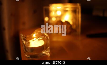 Kerzenlicht in Glas kleinen Glas. Dunkle Nacht Hintergrund Stockfoto