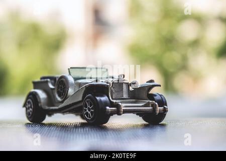 Eine Nahaufnahme eines antiken grauen Autospielzeugs auf einem Tisch Stockfoto