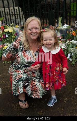 Windsor, Großbritannien. 13.. September 2022. Die kleine zweijährige Eleanor kam, um Blumen in Windsor zu hinterlassen. Auf dem langen Spaziergang in Windsor heute am Cambridge Gate of Windsor Castle wurden wunderschöne Blumengebete in Erinnerung an Ihre Majestät, die Königin, zurückgelassen. Quelle: Maureen McLean/Alamy Live News Stockfoto