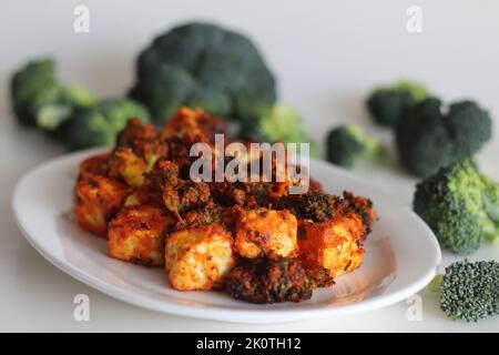 Tandoori Paneer Brokkoli. Quark-Würfel und Brokkoli-Röschen, mariniert mit Joghurt und Gewürzen und gebraten. Gesunde Vorspeise oder ein abendlicher Schnüpfer Stockfoto