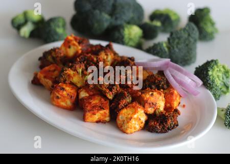 Tandoori Paneer Brokkoli. Quark-Würfel und Brokkoli-Röschen, mariniert mit Joghurt und Gewürzen und gebraten. Gesunde Vorspeise oder ein abendlicher Schnüpfer Stockfoto